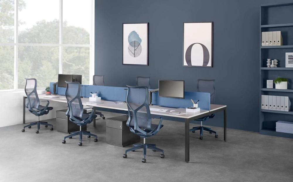 Bureau open space moderne avec rangées de postes de travail équipés de moniteurs LCD double écran, téléphones IP et claviers
